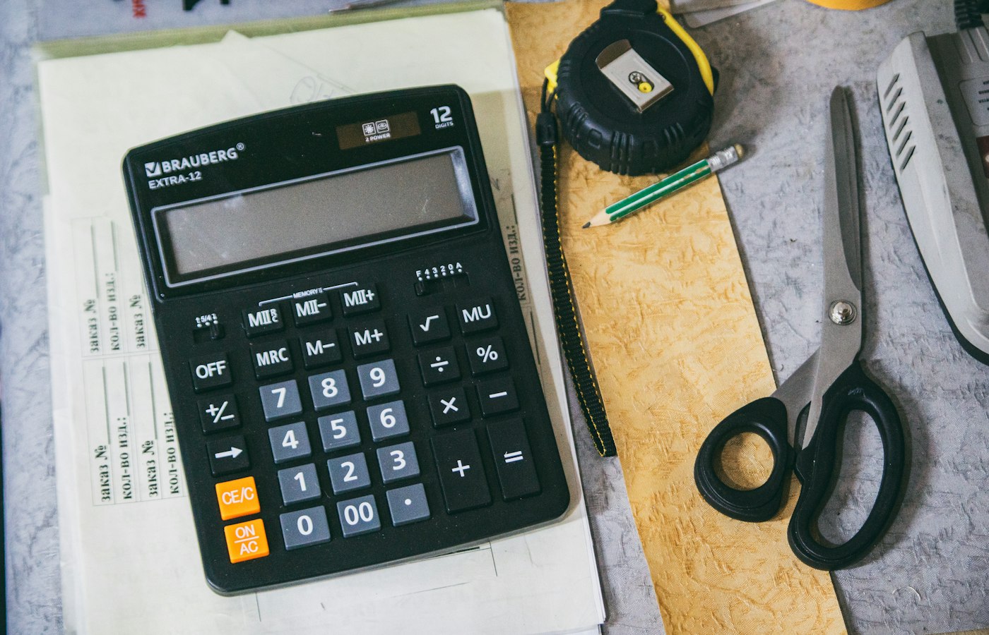 Calculadora e material de escritório sobre uma mesa de trabalho